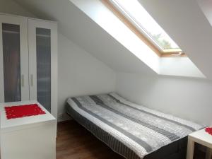 a bed in a white room with a window at Borówka w Blue Mare in Łukęcin