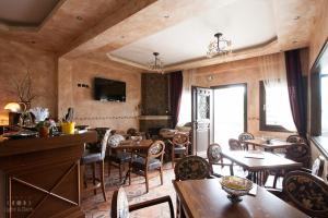 ein Wohnzimmer mit Holzwänden, Tischen und Stühlen in der Unterkunft Oreiades Guesthouse in Parthenonas
