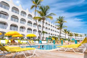 un hôtel avec une piscine, des chaises et un bâtiment dans l'établissement Belair Beach Hotel, à Philipsburg