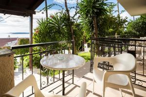 un patio con tavolo e sedie sul balcone. di Irilena Studios and Apartments a Lassi