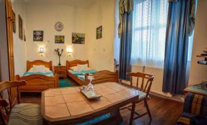 Sala de estar con 2 camas y mesa en Guesthouse Ilona, en Veľký Kamenec