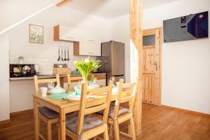 Il comprend une cuisine et une salle à manger avec une table et des chaises en bois. dans l'établissement Apartament w Rynku, à Ustrzyki Dolne