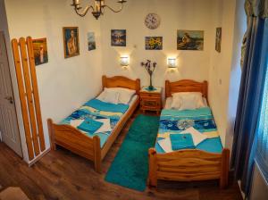 two beds in a small room with at Guesthouse Ilona in Veľký Kamenec