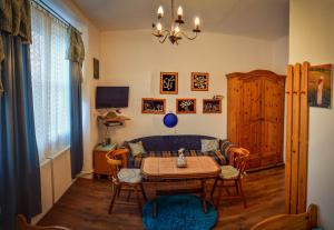 sala de estar con mesa y sofá en Guesthouse Ilona, en Veľký Kamenec