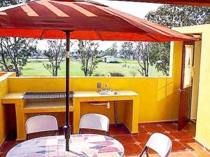 a table with a red umbrella on a patio at La Rosa House in San Miguel de Allende