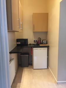 a small kitchen with a counter and a refrigerator at Apartment close to Pavilion gardens in Buxton