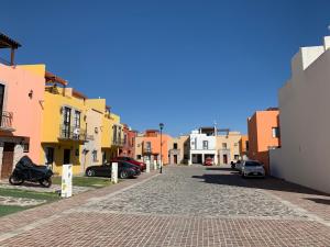 a cobblestone street in a city with buildings at La Rosa House in San Miguel de Allende