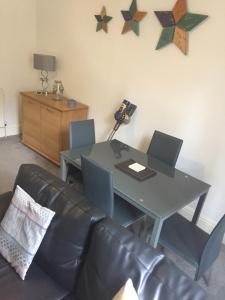 a living room with a table and a couch at Apartment close to Pavilion gardens in Buxton