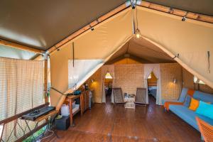 a living room with a blue couch in a tent at Losinj Glamping - Camp Čikat - Wild in Mali Lošinj