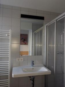 Baño blanco con lavabo y espejo en DAV-Haus (Alpenverein), en Obertauern