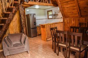 eine Küche mit einem Tisch und Stühlen sowie einem Kühlschrank in der Unterkunft Cabañas Ecoturismo la Pancha in Puerto Aisén