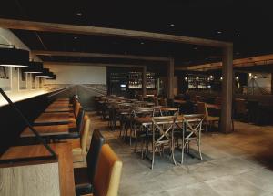 un restaurant avec des tables et des chaises et un bar dans l'établissement Complexe Hotelier Le 55, à Bécancour