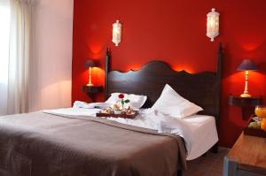 a bedroom with a large bed with red walls at Casa Bela Moura, Boutique Hotel & Wine in Porches