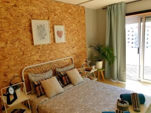 - une chambre avec un lit et un mur en pierre dans l'établissement SunHouse Room, à Albufeira