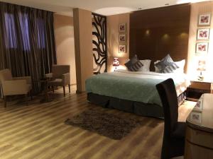 Habitación de hotel con cama, mesa y sillas en ذرا للأجنحة الفندقية 2, en Al Bukayriyah