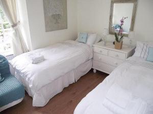 a bedroom with two beds and a dresser and a mirror at Kirkmay House in Crail