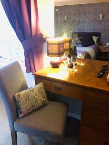 
a table with a chair and a bottle of wine at Bwlch Y Fedwen Bed and Breakfast in Porthmadog
