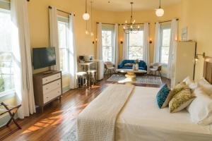 a bedroom with a large bed and a living room at Abita Springs Hotel in Abita Springs