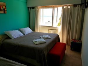 een slaapkamer met een bed met twee handdoeken erop bij Hotel Flamingo in Bariloche