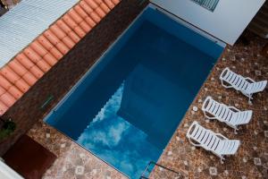 2 sillas de jardín junto a una piscina en Posada del Angel Hotel, en Tarapoto