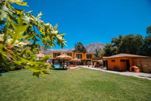 - une vue sur une maison avec une cour herbeuse dans l'établissement Cajón del Maipo Lodge, à San José de Maipo