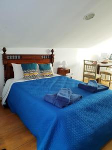a blue bed with two towels on top of it at Casa do Armador in Setúbal