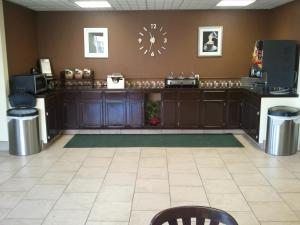 a waiting room with a counter and a clock on the wall at Magnuson Hotel Red Baron in Garden City