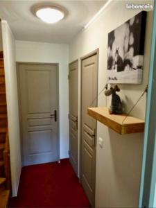 um quarto com um corredor com uma porta e um piso vermelho em Les terrasses d azur em Isola 2000