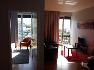 uma sala de estar com um sofá e uma grande janela em Apartamentos América - Blue Sea no Funchal