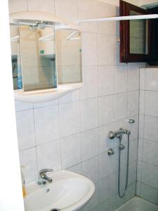 a bathroom with a sink and a shower with a mirror at Apartment in Lopar/Insel Rab 17747 in Lopar
