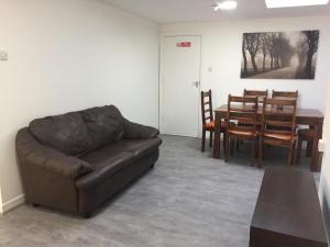 a living room with a brown couch and a table at Sama's Stylish Hotel Room 4 in Manchester