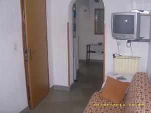 uma sala de estar com uma televisão e um sofá em Materada 22 em Porec
