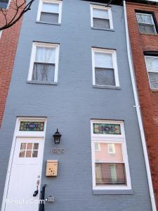 巴爾的摩的住宿－EN SUITE NEXT TO FELLS POINT，蓝色的建筑,有白色的窗户和标志