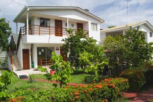 a white house with a garden in front of it at Cabañas Green Yard in San Andrés