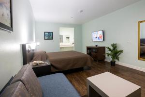 une chambre d'hôtel avec un lit et un canapé dans l'établissement Hotel Bel Air, à Houston