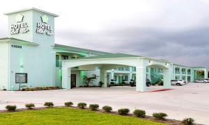un grand bâtiment blanc avec un parking dans l'établissement Hotel Bel Air, à Houston