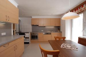 kuchnia z drewnianymi szafkami i drewnianym stołem w obiekcie Ferienhaus Nadine w mieście Kappl