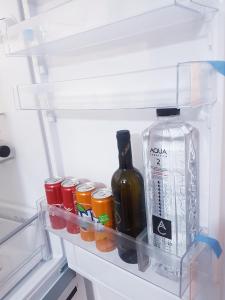 an open refrigerator with a bottle of alcohol and other drinks at Dream Apartment Brasov - West in Braşov