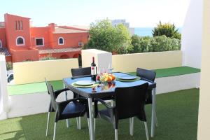 een zwarte tafel met stoelen en een fles wijn bij Apartamento Maria in Lagos