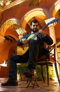 a man sitting on a chair with a guitar at Hotel Casa Del Poeta in Seville