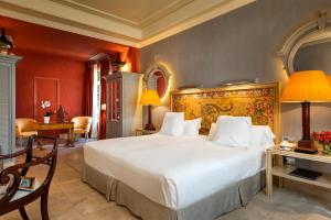 
a hotel room with two beds and a table at Hotel Casa Del Poeta in Seville
