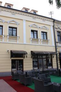 un edificio con un montón de sillas delante de él en Garni Hotel Beograd, en Negotin