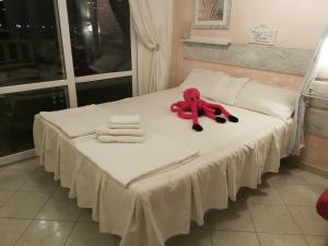 un oso de peluche rojo sentado en la parte superior de una cama en Apartments Paradiso, en Budva