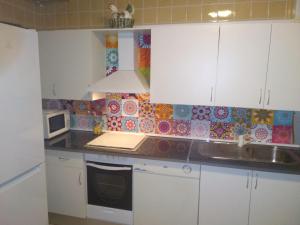 a kitchen with white cabinets and a microwave at Casa de las Lanzas in Setenil
