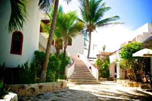 a stairway leading up to a building with palm trees at Pelicano Inn Playa del Carmen - Beachfront Hotel in Playa del Carmen