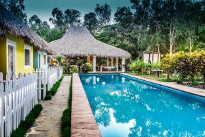 a villa with a swimming pool and a house at Las Dunas Surf Resort in Aposentillo