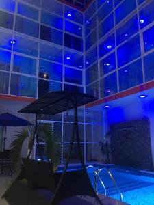a swimming pool with an umbrella in a building at Hotel Empresarial in Paraíso