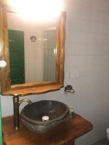 een badkamer met een stenen wastafel en een spiegel bij Main House “El Estanco 14” in Vega de San Mateo