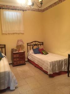 1 dormitorio con 2 camas y mesita de noche con lámpara en Main House “El Estanco 14”, en Vega de San Mateo
