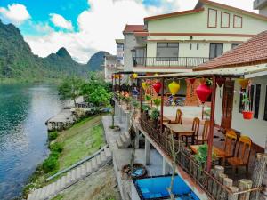 峰牙Phong Nha Coco Riverside的河边的一座带桌椅的建筑